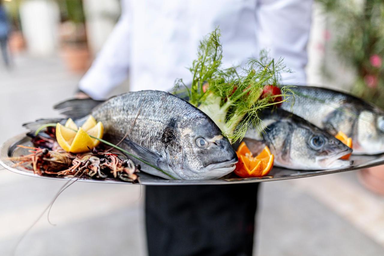 Lighthouse Golf & Spa Hotel Balchik Extérieur photo A waiter holding a platter of fish